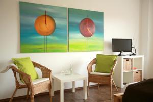 a living room with two chairs and a tv at Pension Kerckenhof in Xanten