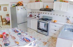 een keuken met een koelkast, een fornuis en een tafel bij Casa grande y privada, jardín & estacionamiento in Salina Cruz