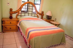 een slaapkamer met een bed en een tafel met een lamp bij Casa grande y privada, jardín & estacionamiento in Salina Cruz
