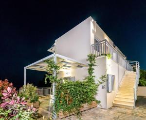 una casa bianca con scale e piante di Athina Residence a Lentas