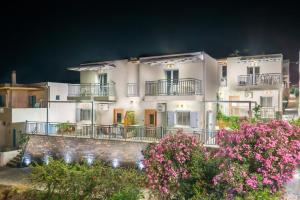 a white building with pink flowers in front of it at Athina Residence in Lentas