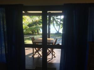uitzicht op een tafel en stoelen vanaf een deur bij Shoreline Escape Rarotonga in Rarotonga