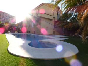 a swimming pool in front of a house at Hostal Mont Royal in Alicante