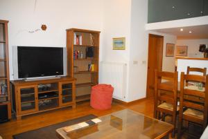 uma sala de estar com uma televisão de ecrã plano e uma mesa em Luxurious Loft with Jacuzzi em Heraclião