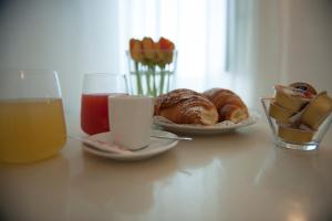 a table with a plate of pastries and a glass of orange juice at Hotel Villa Felice Relais in Amalfi