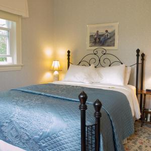 A bed or beds in a room at Farmhouse Inn B&B