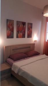 a bedroom with a bed with three paintings on the wall at Bella Vista in Cabo Negro
