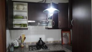 a kitchen with black cabinets and a sink and a light at Bella Vista in Cabo Negro