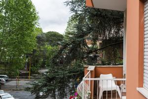 Un balcón con una silla blanca y un árbol en Roma Talenti Breme B&B, en Roma