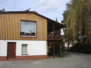 ein Haus mit einem Holzdach und einem Fenster in der Unterkunft Harzer Ferienpension in Timmenrode