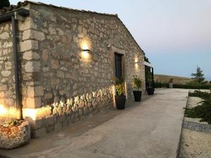 a stone building with potted plants on the side of it at La Casa del Geco in Avola