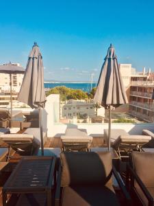 eine Terrasse mit Stühlen und Sonnenschirmen auf dem Dach in der Unterkunft Terreno Studios in Palma de Mallorca