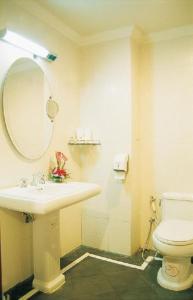 a bathroom with a sink and a toilet and a mirror at LK Metropole in Pattaya