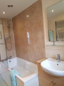 a bathroom with a tub and a sink and a mirror at 6 Seatown, Lossiemouth in Lossiemouth +25 photos