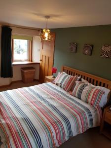 a bedroom with a large bed with a striped blanket at 6 Seatown, Lossiemouth in Lossiemouth