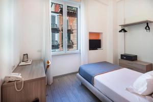 Un dormitorio con una cama y un escritorio y una ventana. en IstayinToledo Luxury Guest House, en Nápoles