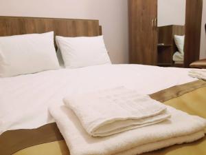 a bed with white towels sitting on top of it at Hotel Classic in Tbilisi City