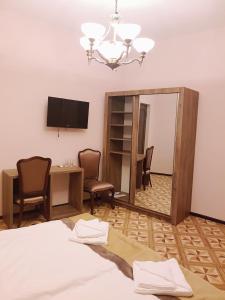 提比里斯的住宿－Hotel Classic，卧室配有镜子、桌子和书桌