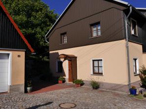 a house with a brown roof and a garage at Bergblick in Saupsdorf