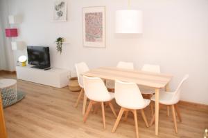 ムルシアにあるApartamento Limon Murciaのダイニングルーム(木製テーブル、白い椅子付)