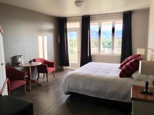 a bedroom with a bed and a table and chairs at Auberge - Village Grande Nature Chic-Chocs in Cap-Chat