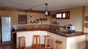 TeguesteにあるVilla Alisのキッチン(カウンター、スツール、冷蔵庫付)