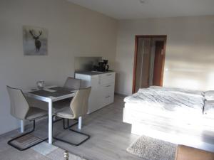 a bedroom with a bed and a table and chairs at Appartement Ausblick in Hahnenklee-Bockswiese