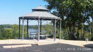 einen Pavillon mit einem Picknicktisch vor einem See in der Unterkunft Rivers EDGE MOTEL in Louisiana
