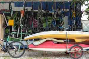 a surfboard on a cart in front of a garage at Himara Hostel in Himare