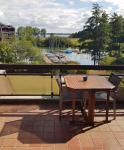 een tafel en stoelen op een balkon met uitzicht op een rivier bij Marina View in Bad Zwischenahn