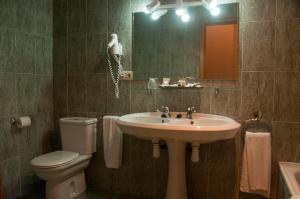 a bathroom with a sink and a toilet and a mirror at Hotel Amoretes in La Molina