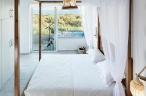 a bedroom with a canopy bed with a window at Kallia Luxury private in Ierapetra