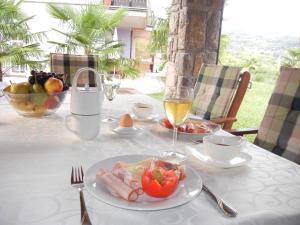 a table with a plate of food and a glass of wine at Villa Laurea in Lovran