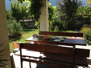 a wooden bench with a plate of fruit on it at BnB Chantevent in Sierre