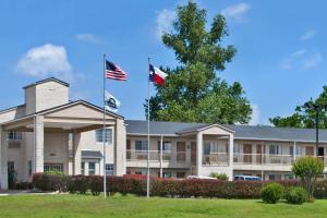 two flags flying in front of a building at Days Inn by Wyndham Kerrville in Kerrville