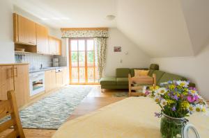 a living room with a couch and a table with flowers at Grainmeisterhof in Niederwaldkirchen