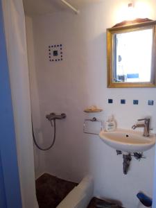 a bathroom with a sink and a shower at Traditional stone house with breathtaking view in Serifos Chora +23 photos