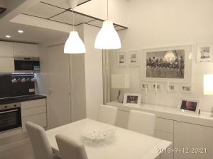 a white kitchen with a white table and chairs at Milan center Luxury House in Sesto San Giovanni