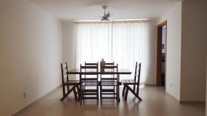 mesa de comedor con sillas y ventana en Arraial Temporada Le Bon Vivant, en Arraial do Cabo