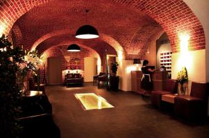 a room with a brick wall and a woman in a bar at The Granary - La Suite Hotel in Wrocław