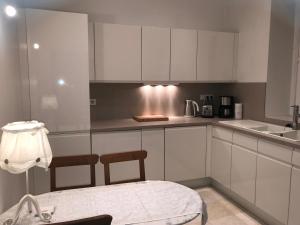 a kitchen with white cabinets and a table and a sink at 2 Boulevard de Nancy in Strasbourg