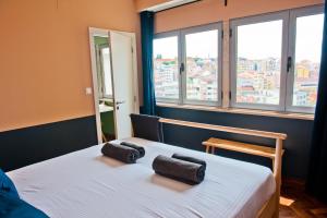 um quarto com uma cama branca com duas toalhas em Margaritas Day 2C em Lisboa