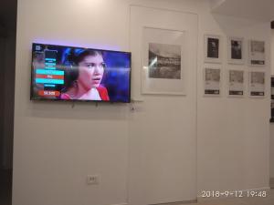 a flat screen tv on a white wall with pictures at Milan center Luxury House in Sesto San Giovanni