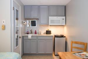 a small kitchen with white cabinets and a sink at Seacoast Motel in Wells