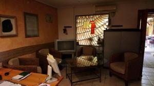 a living room with a desk and a stained glass window at Hostal Isis in Arcas