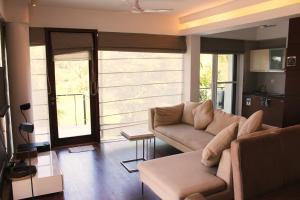 ein Wohnzimmer mit einem Sofa und einigen Fenstern in der Unterkunft Luxurious 2BHK for Ultimate Holiday Experience in Goa, Candolim North Goa in Candolim