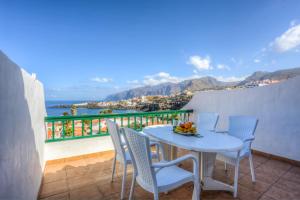 una mesa y sillas en un balcón con vistas al océano en Ocean and Mountain View Penthouse by Dream Homes Tenerife, en Puerto de Santiago