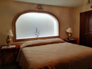 ein Schlafzimmer mit einem Bett und einem großen Fenster in der Unterkunft Hotel Posada Maria Bonita in Bernal
