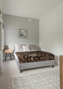 ロンドンにあるBrondesbury Apartmentsの白いベッドルーム(ベッド1台、ラグ付)