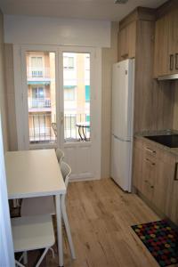 a kitchen with a white refrigerator and a table at B&B LOS LLANOS in Estella